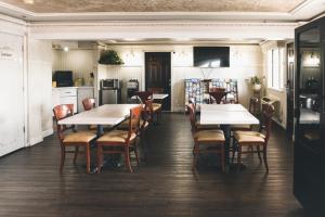 una sala da pranzo con tavoli e sedie e una cucina di Niwas Inn a Fife