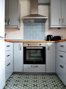 a kitchen with white cabinets and a stove top oven at Béal na Banna in Coleraine
