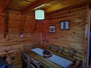 a dining room with a table in a log cabin at Cabañas Aucaman in Villa Pehuenia
