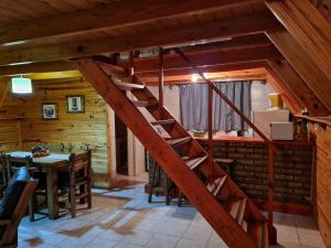 a wooden staircase in a room with a table at Cabañas Aucaman in Villa Pehuenia