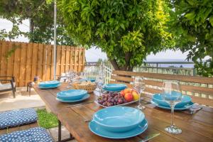 - une table en bois avec des assiettes de fruits et des verres à vin dans l'établissement Mediterranean House - Forest Marjan, à Split