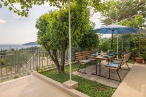- une table et des chaises avec un parasol sur la terrasse dans l'établissement Mediterranean House - Forest Marjan, à Split