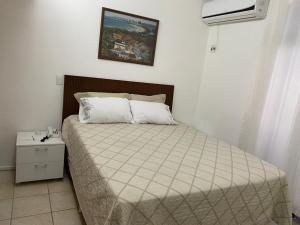 a bedroom with a bed and a picture on the wall at Flat beira mar, Olinda 4 Rodas 309 in Olinda