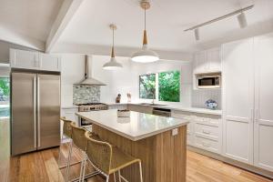 a kitchen with white cabinets and stainless steel appliances at Bright River Rest in Bright