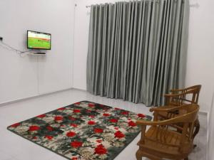 a living room with a television and a rug at Homestay Pasir Tumboh Kota Bharu in Kota Bharu