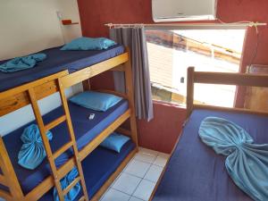 two bunk beds in a room with a window at Mundo da Lua Hostel in Morro de São Paulo