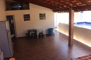 une chambre avec une table et des tabourets dans une maison dans l'établissement Casa com piscina no litoral norte, à Bertioga