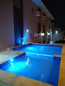 a pool in a hotel at night at Pousada Maré Enseada in Guarujá