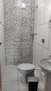 a white bathroom with a toilet and a sink at Casa da Montanha in São Thomé das Letras