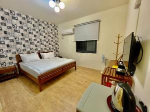 東港的住宿－藍鷺鷥民宿，一间设有床铺和电视的房间