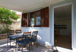 傑澤拉的住宿－Apartments Slađa - 150 m from beach，一个带窗户的庭院里的桌椅