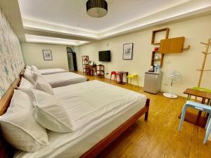 東港的住宿－藍鷺鷥民宿，一间带两张床的卧室和一台电视