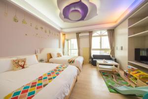 een hotelkamer met twee bedden en een tv bij Childlike B&B in Wujie