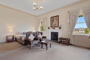 a bedroom with a bed and a chair and a fireplace at Waratah On York in Launceston