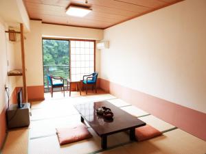 a living room with a table and a dining room at Hotel New Ohruri in Nikko