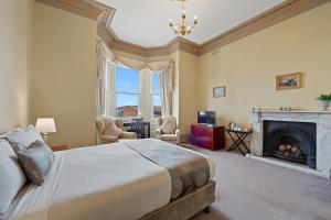 um quarto com uma cama grande e uma lareira em Waratah On York em Launceston