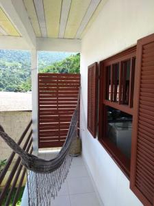 a hammock on the balcony of a house at Guest House Marinas in Angra dos Reis