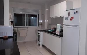 a kitchen with white cabinets and a white refrigerator at Ótimo Apartamento 306, Arraial do Cabo, RJ, Brasil in Arraial do Cabo +27 photos