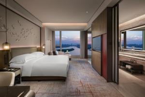 - une chambre avec un grand lit blanc et une grande fenêtre dans l'établissement InterContinental Quanzhou, an IHG Hotel, à Quanzhou