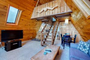 una sala de estar con TV y una escalera en una cabaña en 11 Island Drive, en Madison