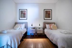 two beds in a room with two lamps and a table at 405 Charming Central renovated lift sleep 4 in Perth