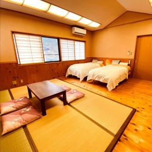 um quarto com duas camas e uma mesa em のと海 em Nanao