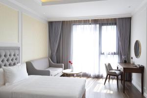 Habitación de hotel con cama, silla y escritorio. en Phu Cuong Hotel Ca Mau en Cà Mau