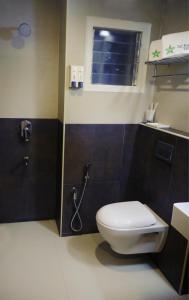 a bathroom with a white toilet and a shower at Taz Kamar Family Hotel in Chennai