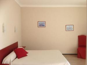 - une chambre avec un lit doté d'oreillers rouges dans l'établissement Saint Jacques, à Sorède