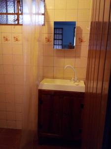 een badkamer met een wastafel en een spiegel bij Residencial Recanto do Sabiá in Alto Paraíso de Goiás
