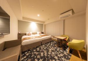 a hotel room with a bed and a table and chairs at Tokyu Stay Kyoto Sanjo-Karasuma in Kyoto