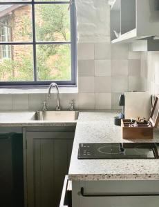 a kitchen with a sink and a stove at Piermont Retreat in Swansea