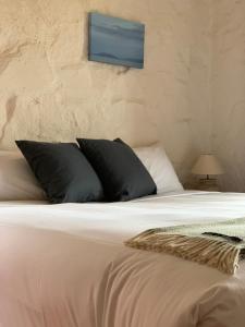 a bed with black and white pillows on it at Piermont Retreat in Swansea