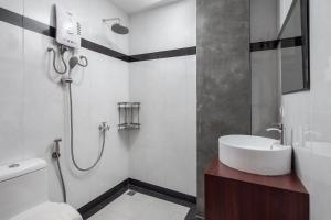 y baño con lavabo y ducha. en Botum Palace Hotel en Phnom Penh