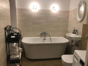 a bathroom with a tub and a sink and a toilet at Luxury Old Town apartment in Vilnius