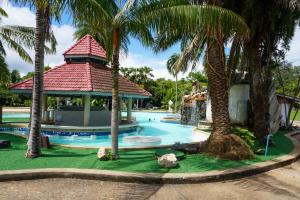 a swimming pool with a gazebo and palm trees at Rockgarden Beach Resort in Mae Pim