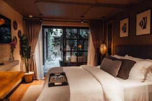 a bedroom with a white bed and a large window at CASA EMILIA B&B Boutique in Mexico City