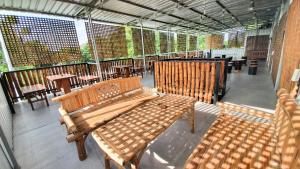 a patio with wooden benches and tables in a building at Omah Pandhoek Family Syariah by Stayku in Nganjuk