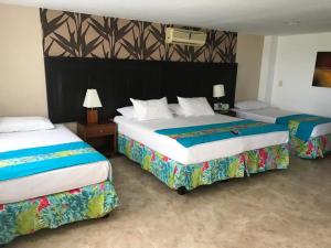 two beds in a hotel room with two at Hotel San Antonio del Cerro in Pereira