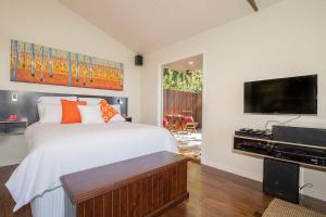 a bedroom with a large bed and a flat screen tv at Byron's Secret in Coorabell Creek +22 photos