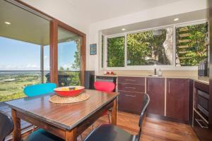 a kitchen with a wooden table and some chairs at Byron's Secret in Coorabell Creek