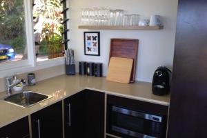 a kitchen with a counter and a sink and a window at Byron's Secret in Coorabell Creek