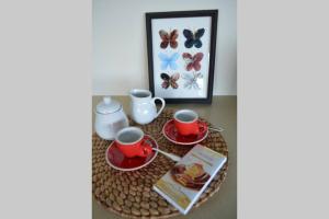 a table with two cups and a tea set on it at Byron's Secret in Coorabell Creek