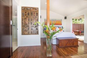 a bedroom with a bed with a vase of flowers at Byron's Secret in Coorabell Creek