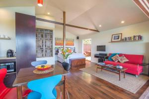 a living room with a red couch and a table at Byron's Secret in Coorabell Creek
