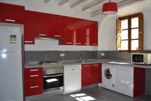 a kitchen with red cabinets and a washing machine at Sa Posada in Estellencs