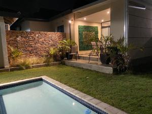 a small backyard with a swimming pool and a patio at iMpongo Royal Lodge in Richards Bay