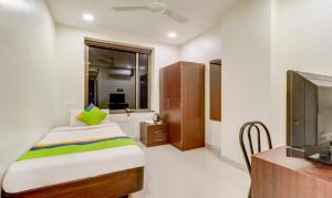 a bedroom with a bed and a tv in a room at Treebo Trend Orange City in Nagpur