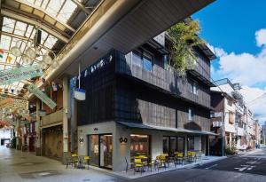 a building with tables and chairs on a city street at DELTA Stay in Kyoto