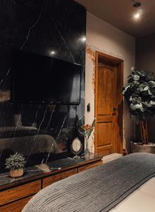 a bedroom with a large flat screen television on a wall at CASA EMILIA B&B Boutique in Mexico City